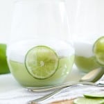 2 clear glass containers of Limesicle Pudding with lime slices and spoons.