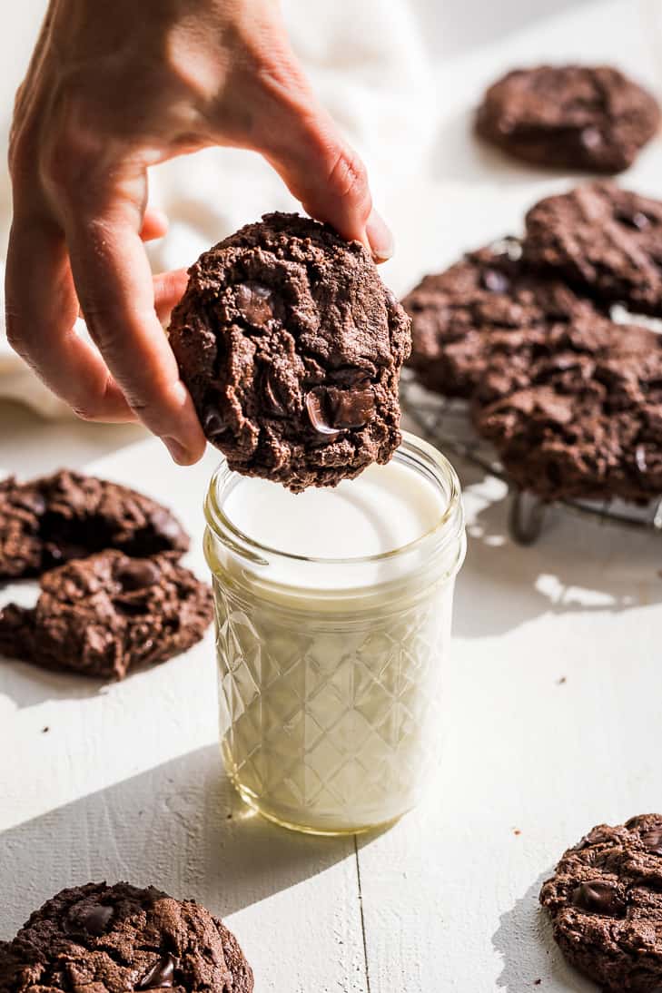 Dunking a Double Chocolate Almond Butter Cookie into a glass of milk.
