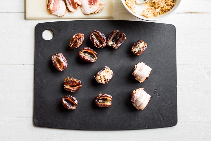 Dates being filled with the chorizo cream cheese mixture and wrapped in bacon.