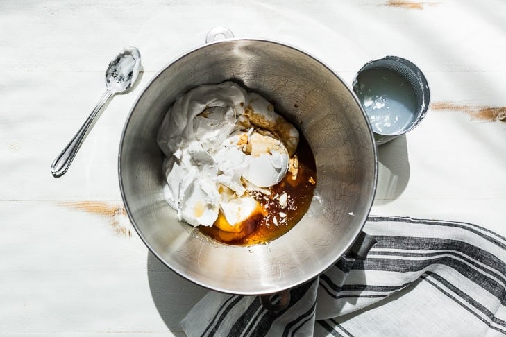 All ingredients for the coconut whipped cream in the bowl of an electric mixer.