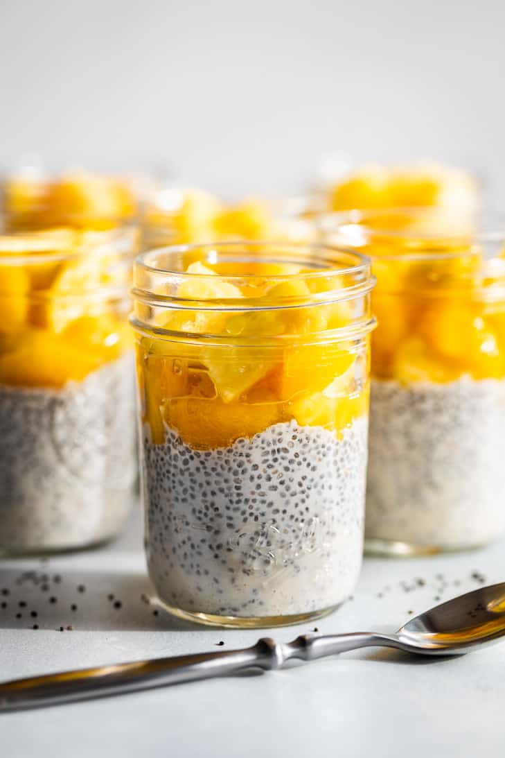 Mason jars of Creamy Coconut Chia Pudding topped with Pineapple and Mangoes!