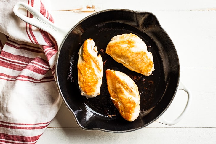 A photo of the pan seared chicken breasts as the first step in the recipe.