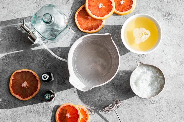 All the ingredients for the Grapefruit Ginger Body Wash placed around a mixing bowl.