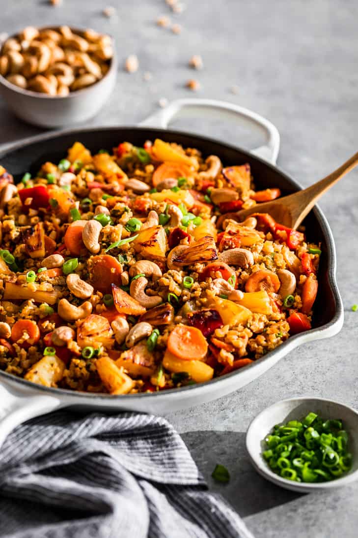 A large white skillet filled with Paleo Pineapple Fried Cauliflower Rice.