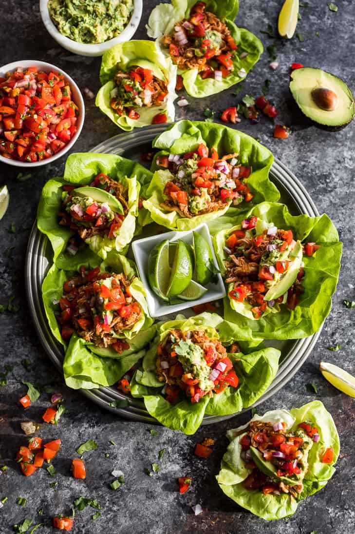 Instant Pot Chicken Tinga Taco Lettuce Wraps on a silver plate with salsa and avocado around it.