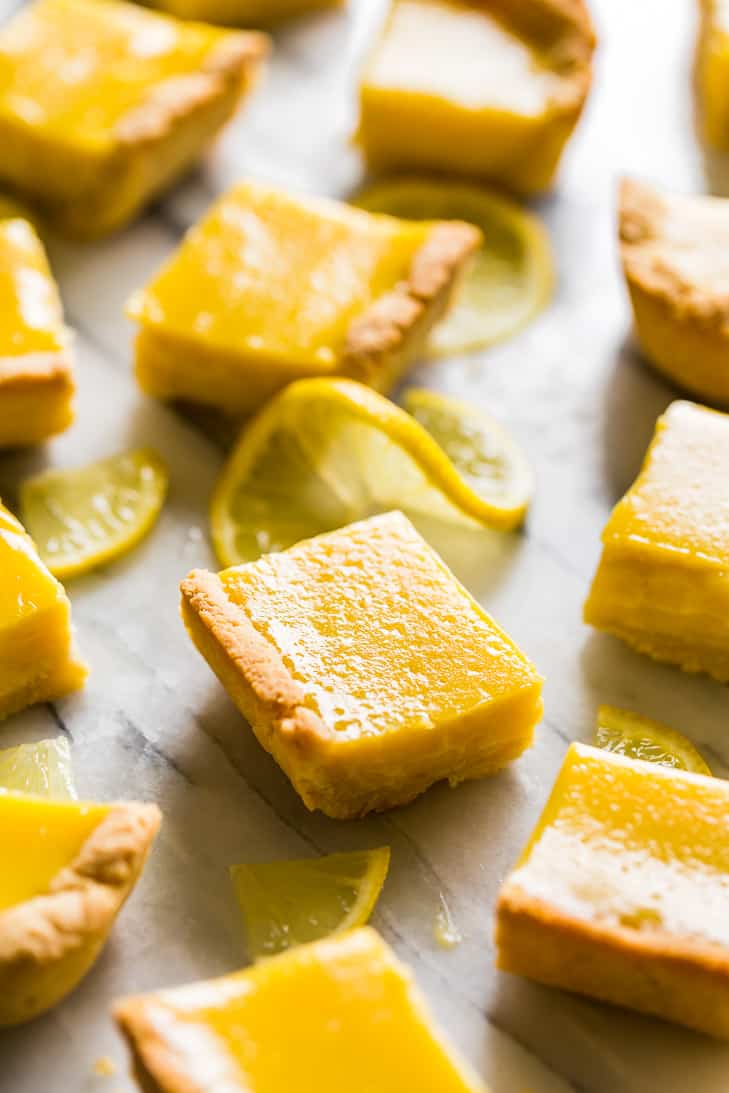 Lemon bars placed on a marble background with lemon slices as a fresh dessert for the 31 Recipes to Make for March.