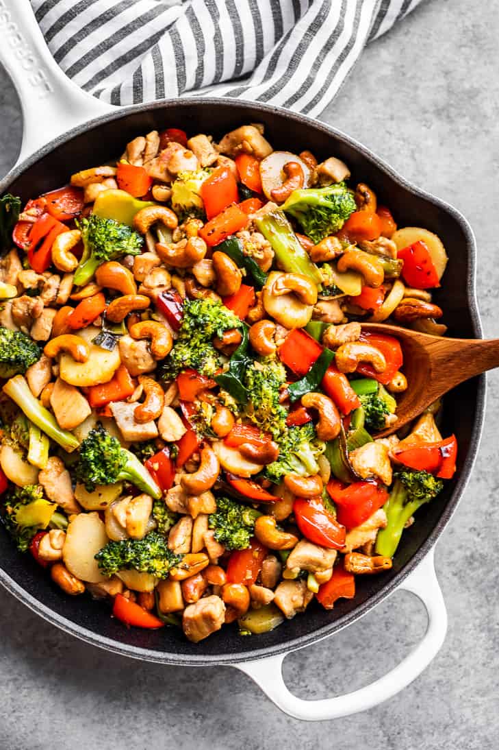 A large white skillet filled with Cashew Chicken.