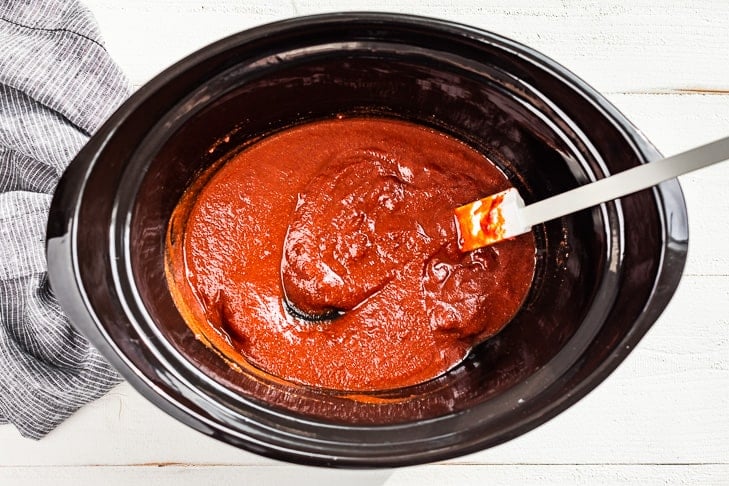 All the sauce ingredients for the recipe mixed together in a slow cooker bowl.