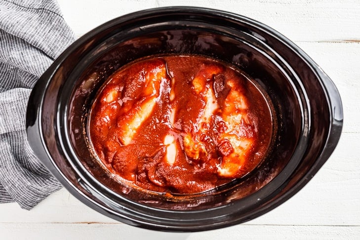 Coating the chicken in the sauce before setting the slow cooker timer.