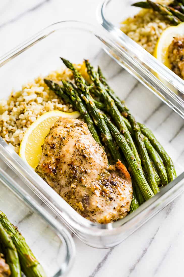 Garlic Herb Chicken and Asparagus Meal Prep in clear glass containers.