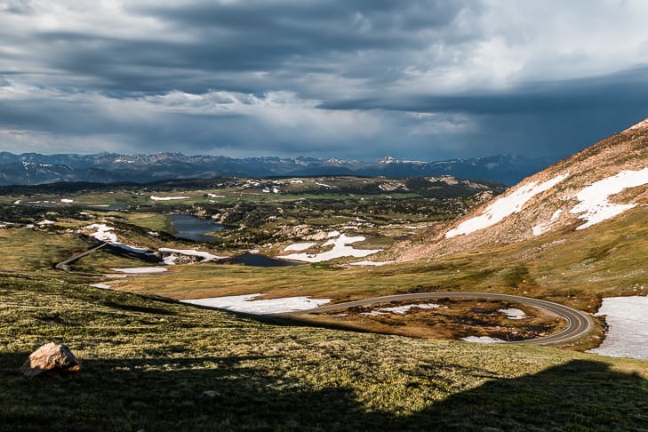 A view looking down on the Beartooth Highway switchbacks with a storm on the horizon.