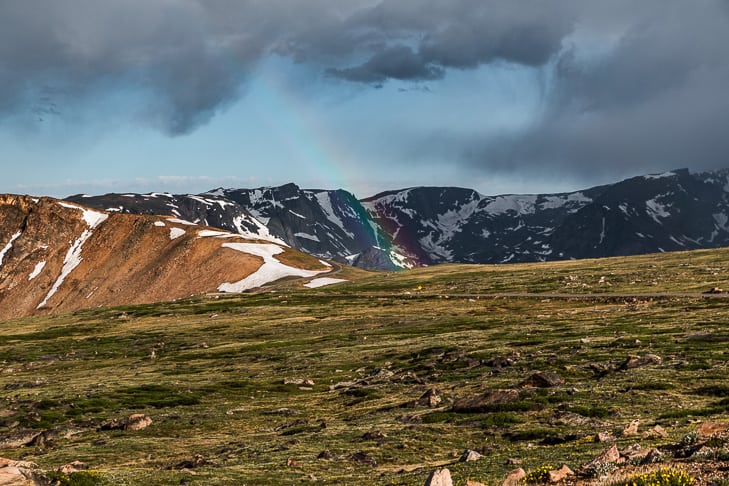 A rainbow coming down over a mountain range.