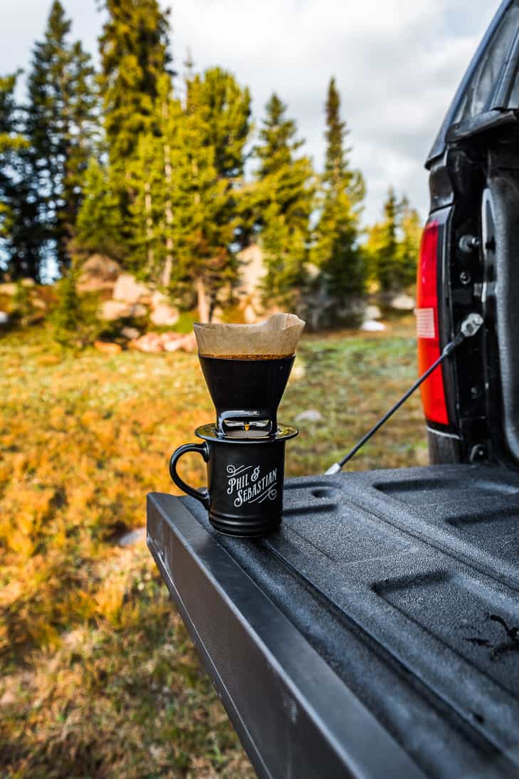 Making camp coffee on the truck tailgate from a campsite near the highway.