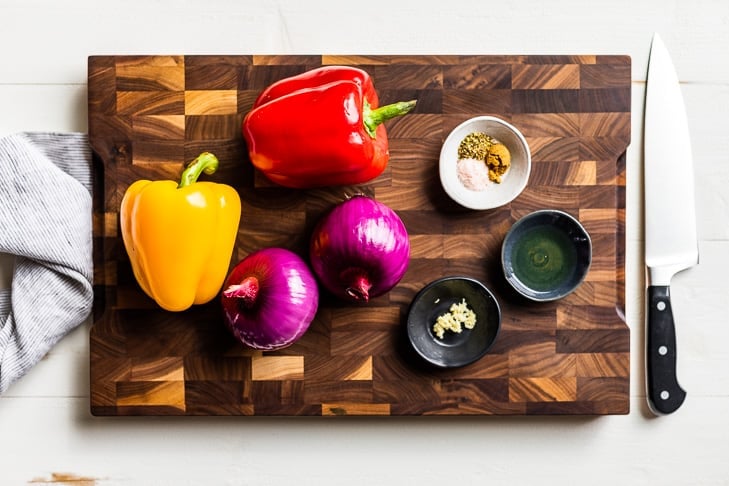 All the ingredients for the Fajita Veggies on a wooden cutting board.