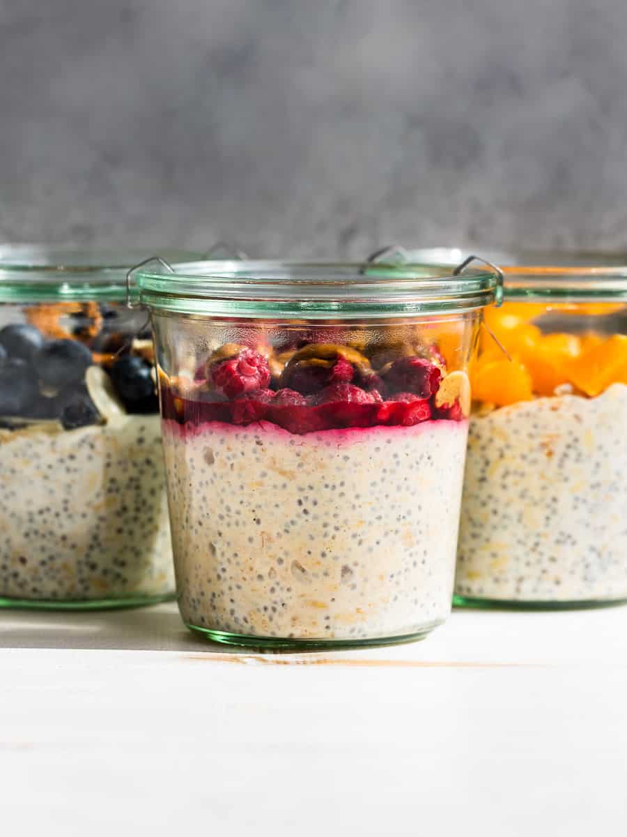 PBJ, Blueberry, and Tropical Overnight Oats in glass jars on a white background.