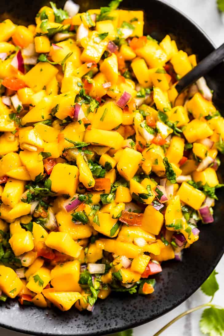 Straight down close view of Mango Salsa in a black bowl.