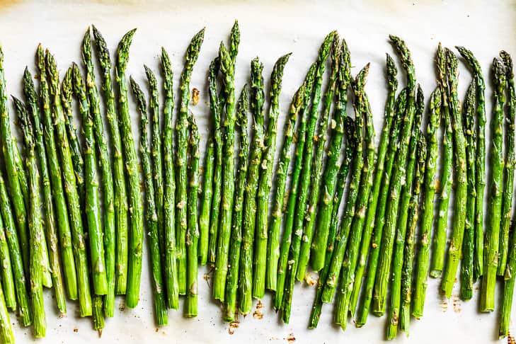 Finished roasted asparagus on parchment paper.