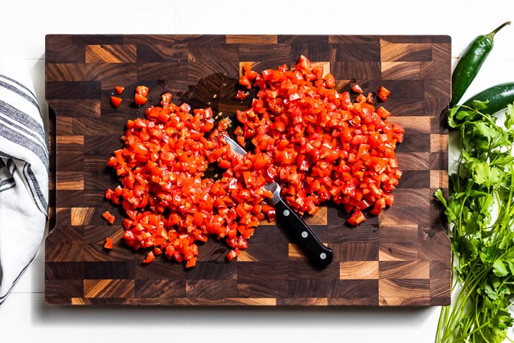 Diced tomatoes on a wooden cutting board.