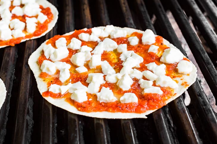 Tortillas with sauce and cheese placed on the grill.