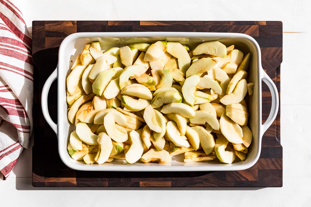 Apple slice in a white baking dish.