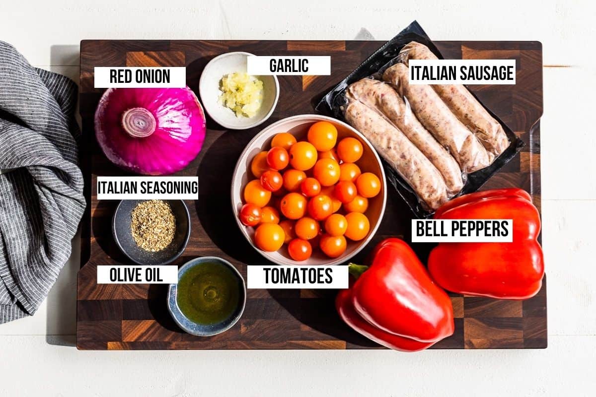 Ingredients for the Sausage and Peppers on a wooden cutting board.