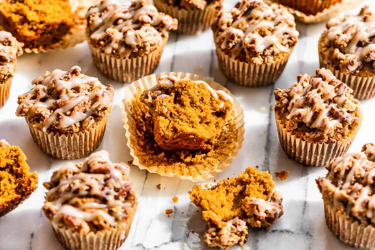 Glazed Almond Flour Pumpkin Muffins with 1 muffin split in half to show texture.