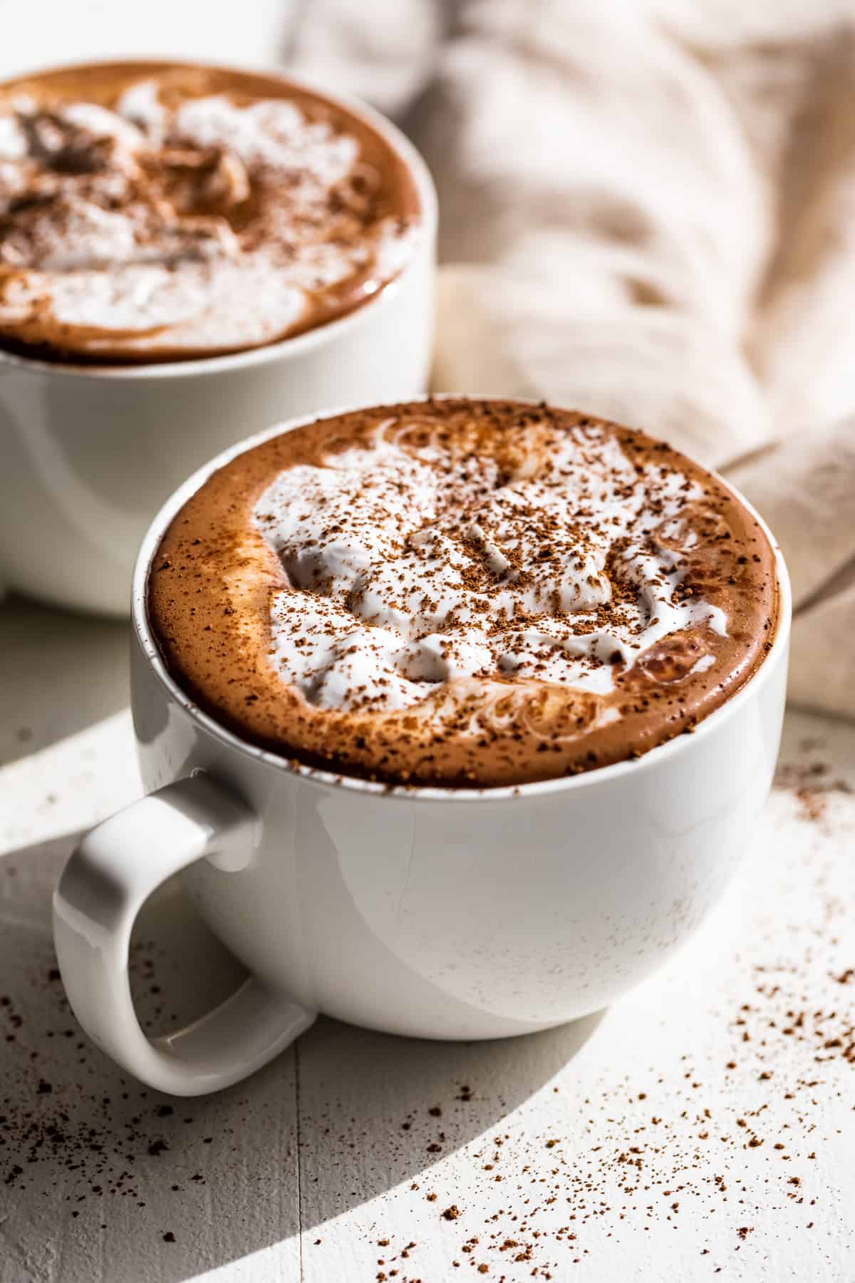 Side view of hot chocolate in two large mugs.