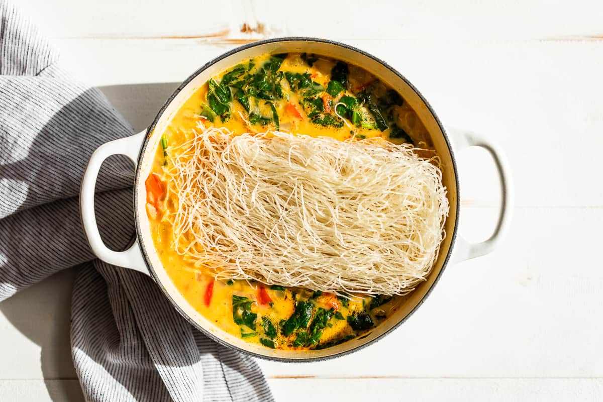 Adding the rice noodles to the finished soup.