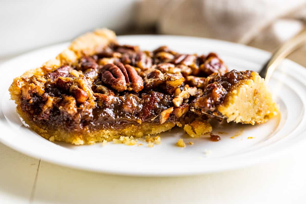 Close view of the texture of the pecan pie bars with a bite out of the side.