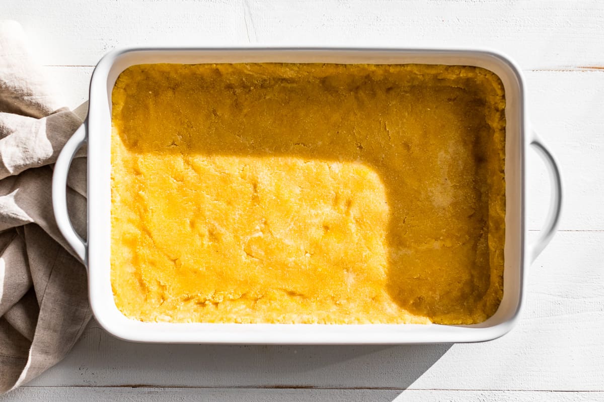 The almond flour crust patted into a white baking dish.