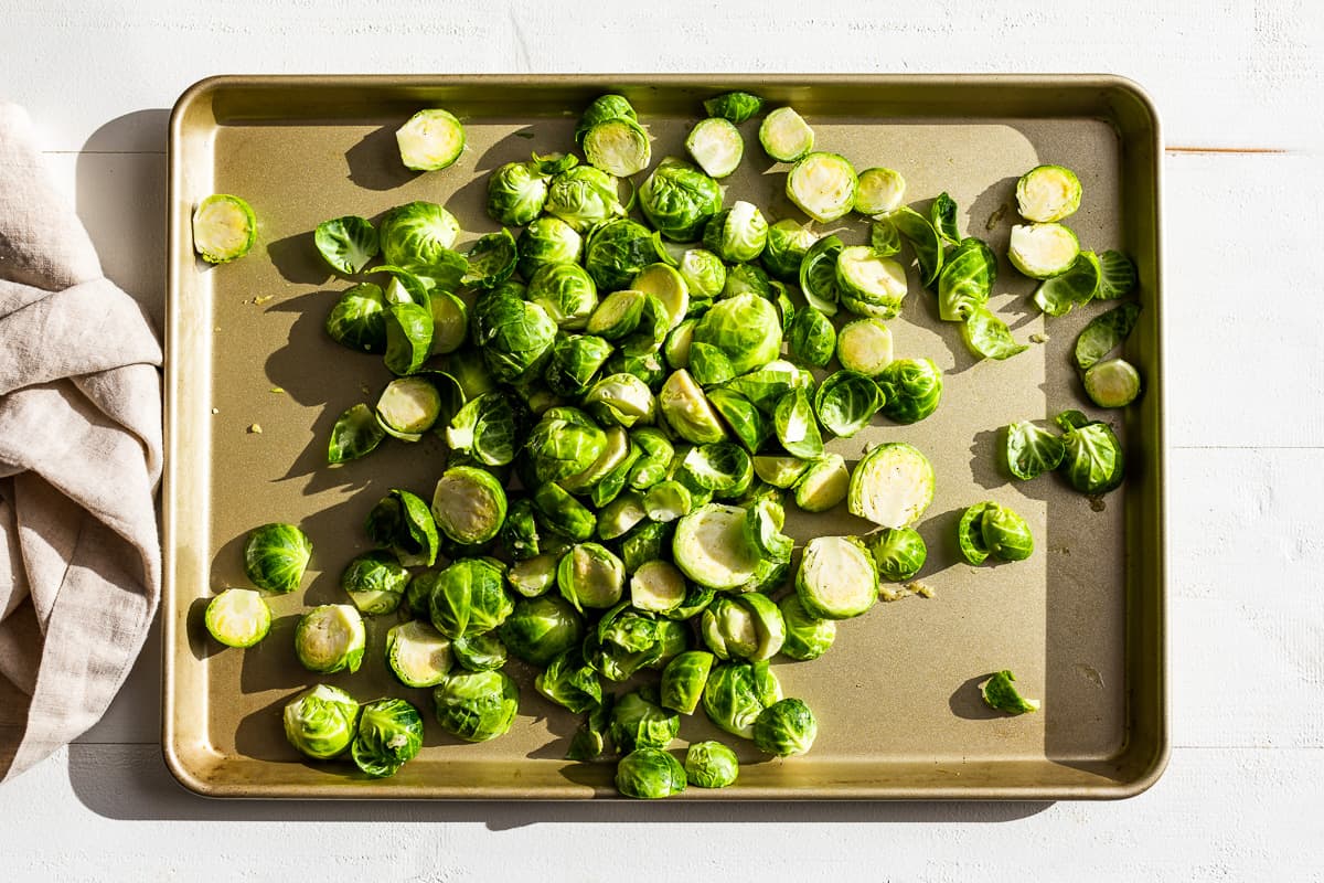 Tossing the halved Brussels sprouts together with the olive oil, garlic, salt and pepper.