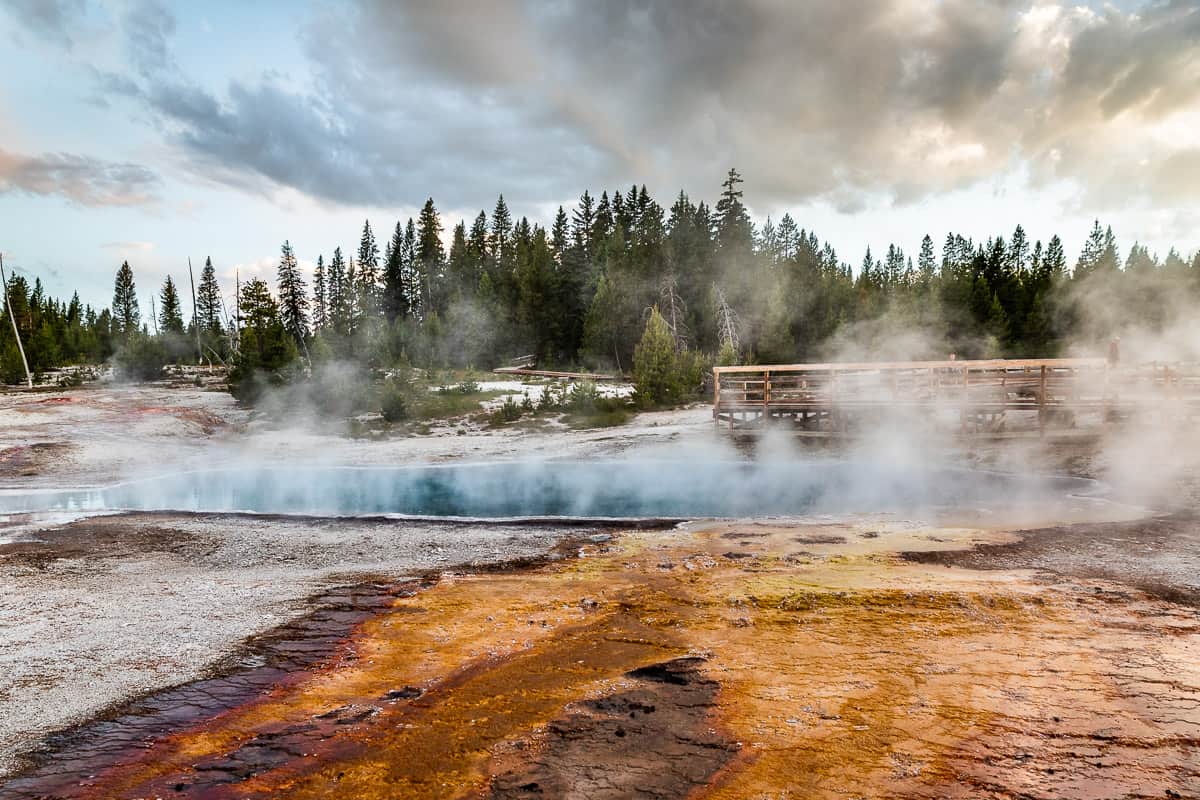 Looking up at the bright blue geyser with the orange bacterial mats flowing out of the front.