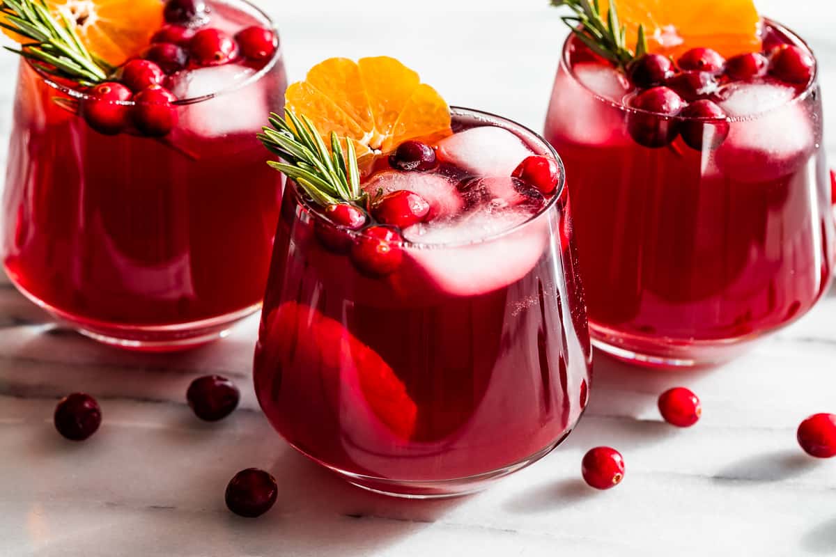 Side view Cranberry Kombucha Mocktails with cranberries around the glasses.