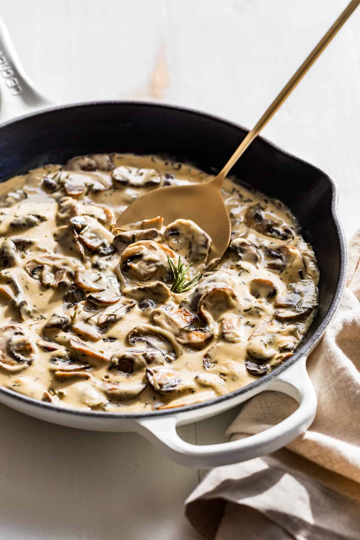 Side view of Mushroom Cream Sauce in a white skillet.