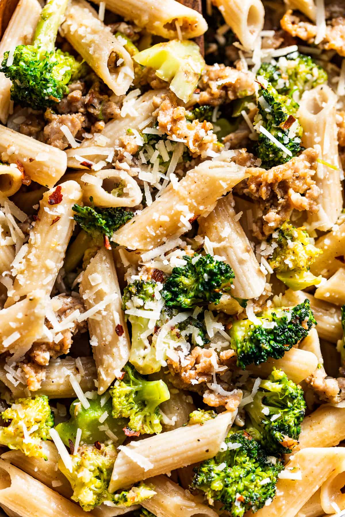 Close macro shot of Sausage Broccoli Pasta sprinkled with parmesan cheese.