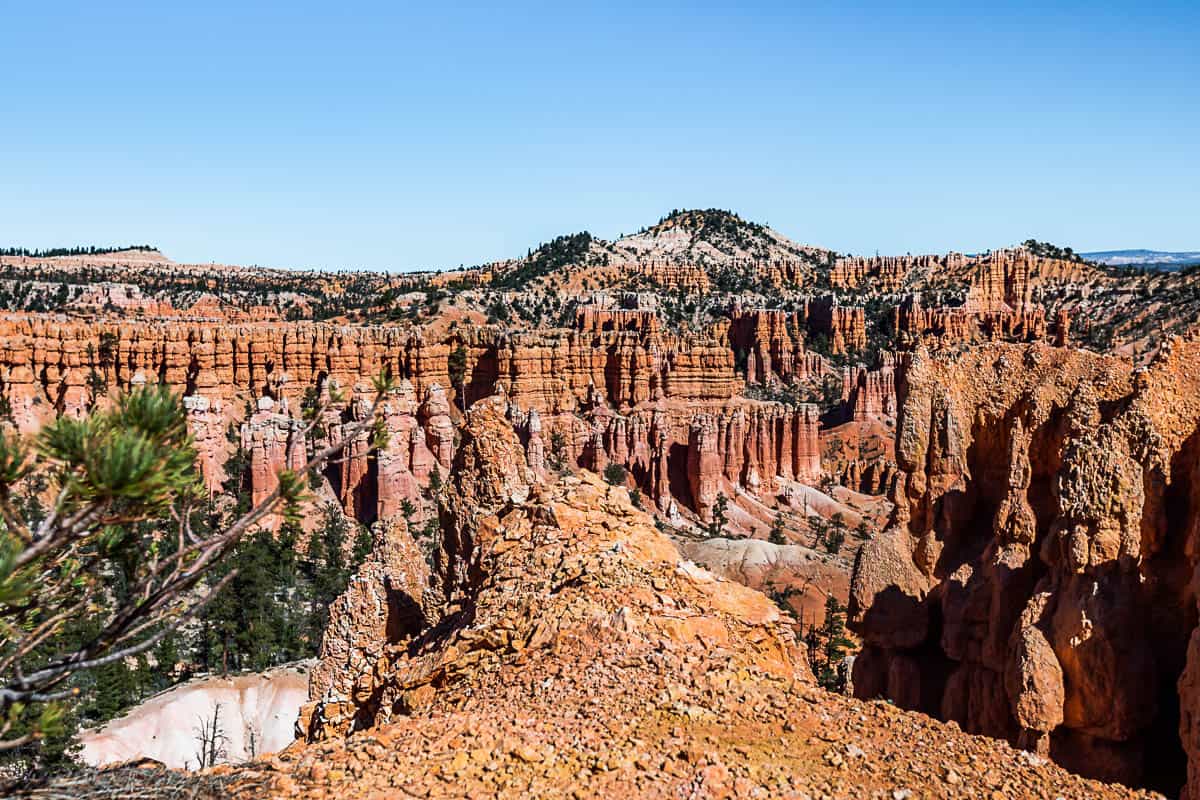 Overlook with hoodoos in the distance and larger mountains in the far distance.