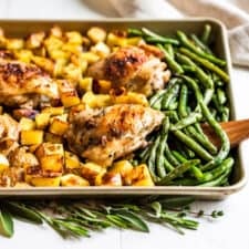 Finished Garlic Butter Chicken with potatoes and green beans on a cookie sheet.