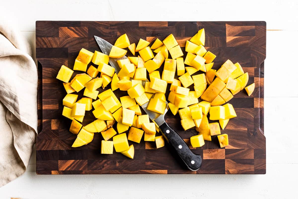Diced up potatoes on a wooden cutting board.