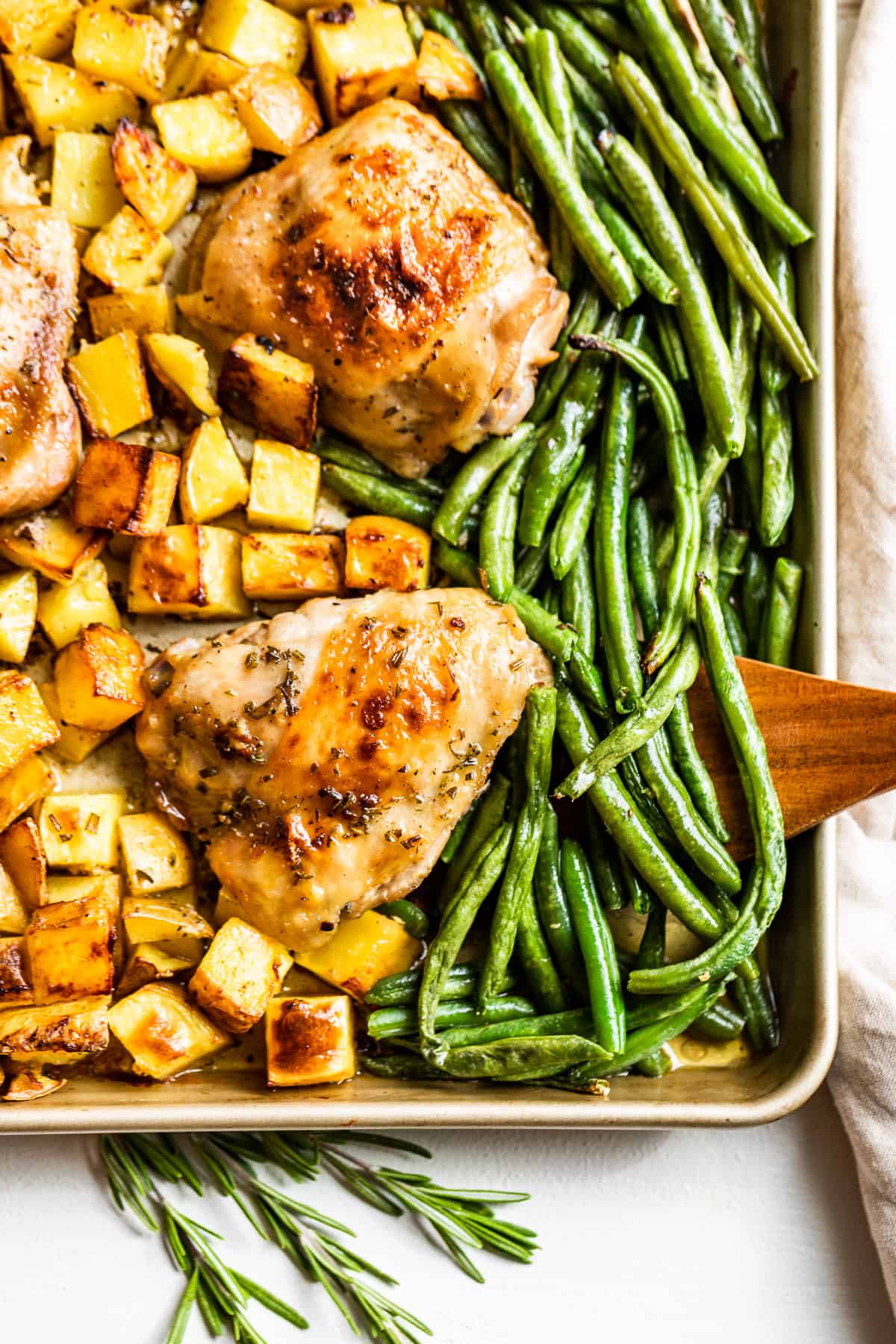 Two Garlic Butter Chicken Thighs with roasted potatoes and green beans.
