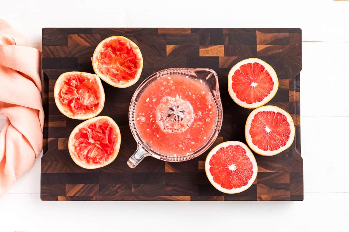 Juicing the grapefruit halves with a glass reamer or juicer bowl.