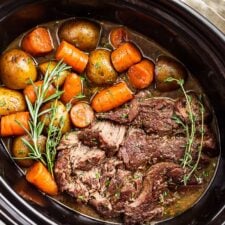 A close side view of the Slow Cooker Pot Roast in the slow cooker bowl.