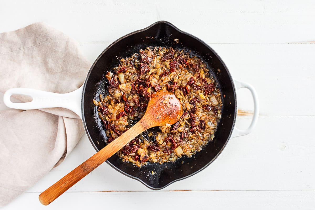 Sautéed onions with sun dried tomatoes and Italian seasoning added to the skillet.