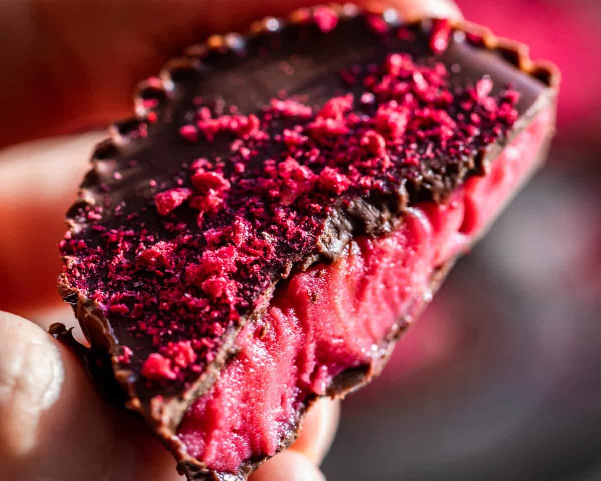 A finished Chocolate Raspberry Candy with a bite taken out of the center.