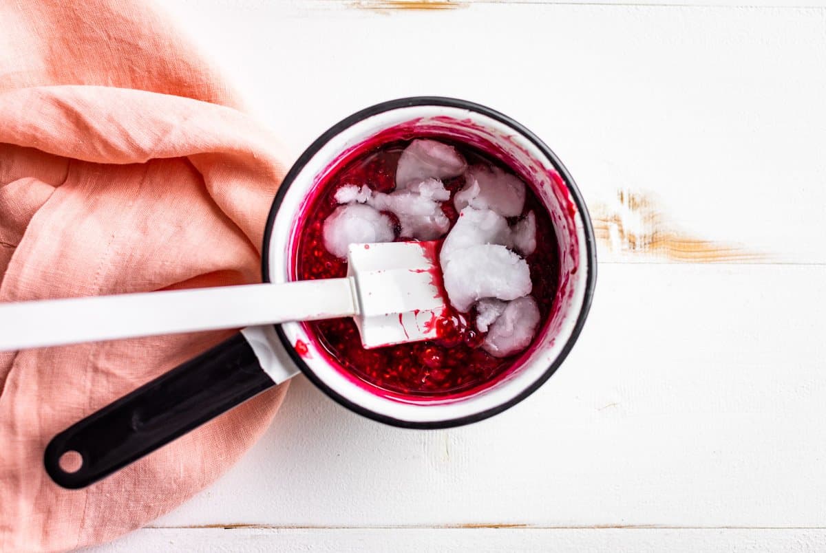 Raspberry filling with coconut oil being whisked in.