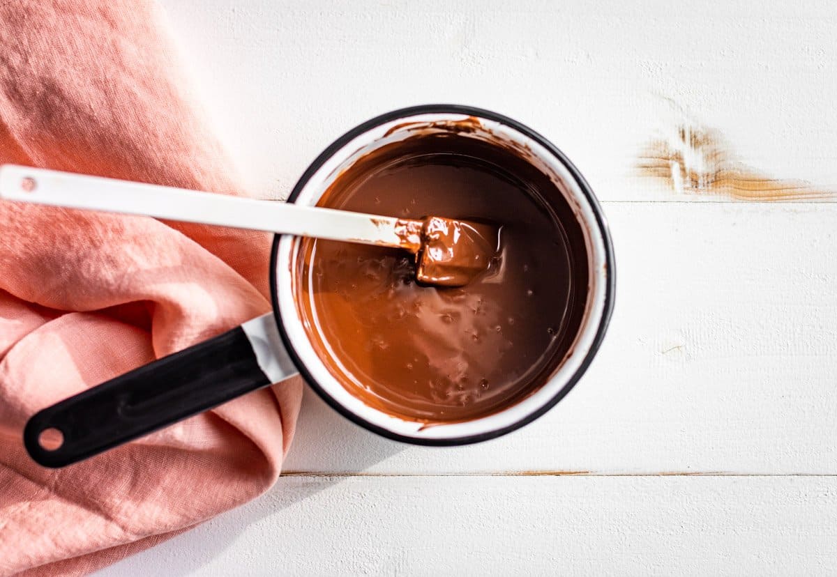 Melted chocolate in a small white saucepan.