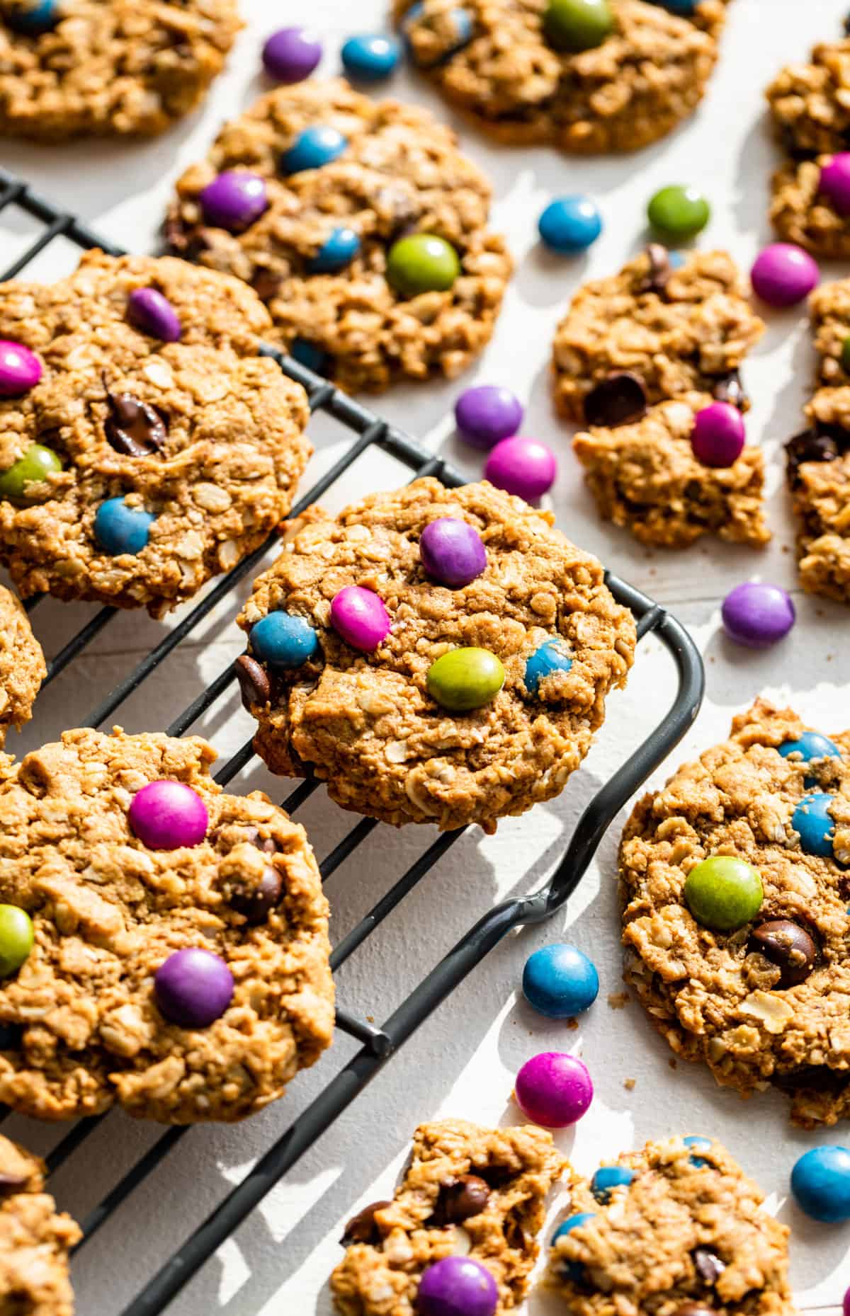 Monster Cookies on a cooling rack with M & M's around them.