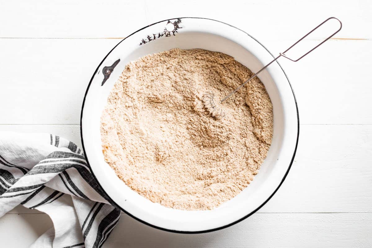 Mixing the flour ingredients together in an enameled mixing bowl.