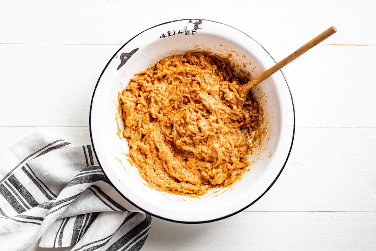 Adding the wet ingredients to the flour grated carrot mixture.