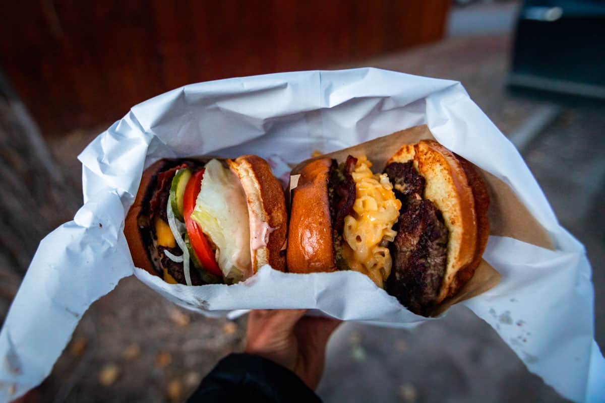 Looking down at two burgers in a white paper bag.