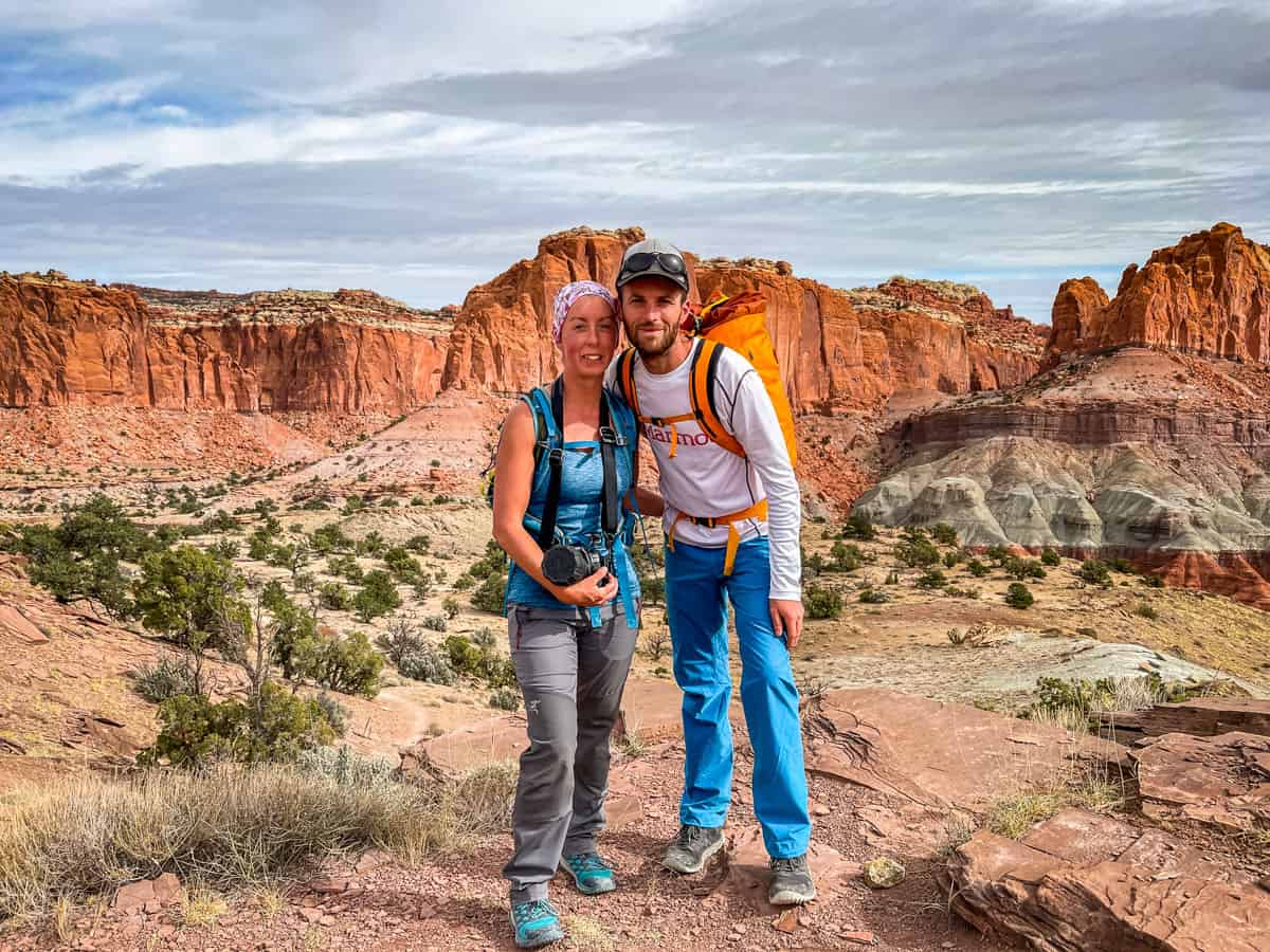 The website authors, (a man and women) standing in front of orange rock formations in Capitol Reef.